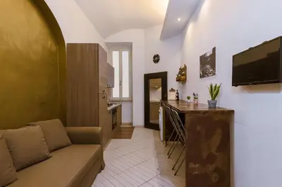 a living room with a couch and a kitchen at Repubblica Apartment in Rome