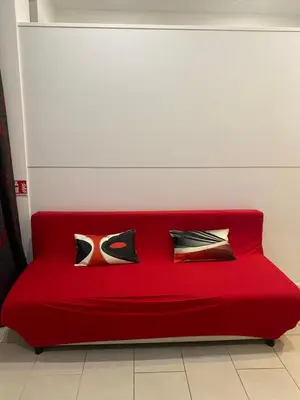 a red couch with pillows on it in a room at La perla del Colosseo in Rome