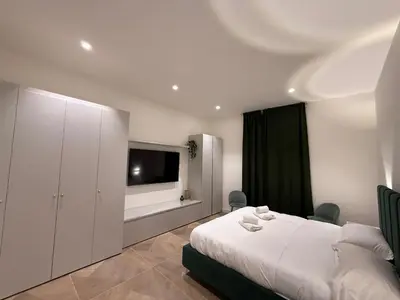 a bedroom with a white bed and a television at Luxury apartments, Piazza di Spagna in Rome