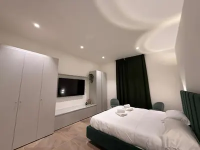 a bedroom with a white bed and a flat screen tv at Luxury apartments, Piazza di Spagna in Rome