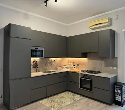 a kitchen with gray cabinets and a stove top oven at Dolce Vita House - 10min walk to Vatican in Rome