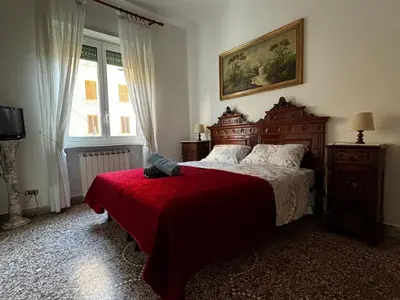a bedroom with a large bed with a red blanket at Vodice Apartment- Between Vatican and Foro Italico in Rome