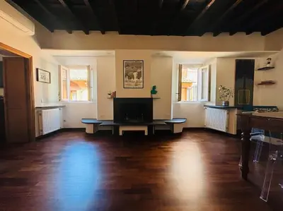 a living room with a wooden floor and a tv at Scala 31 Trastevere in Rome