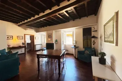 a living room with a wooden table and chairs at Scala 31 Trastevere in Rome