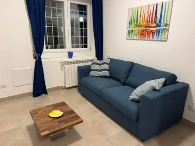 a living room with a blue couch and a table at Trastevere Cozy Retreat in Rome
