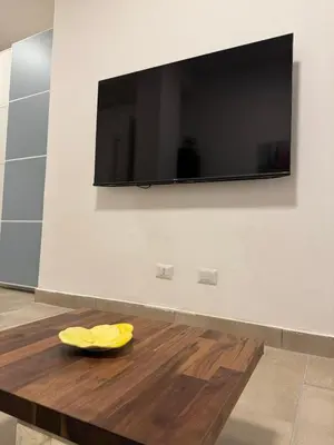 a yellow plate on a wooden table in front of a tv at Trastevere Cozy Retreat in Rome