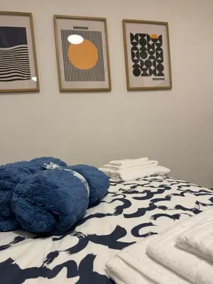 a blue teddy bear laying on a bed with pictures at Trastevere Cozy Retreat in Rome