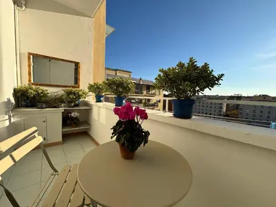 a table with a vase of flowers on a balcony at Living Rome Flaminio - Appartamento parziale - Alloggio ad uso turistico in Rome