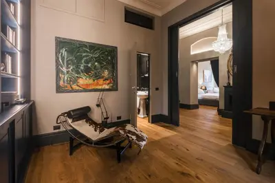 a living room with a chair and a painting on the wall at Mega Royal Suite in Rome