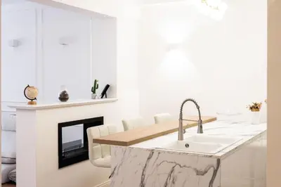 a white kitchen with a sink and a fireplace at Vatican Home 168 in Rome