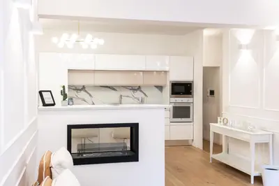 a living room with a fireplace and a white kitchen at Vatican Home 168 in Rome