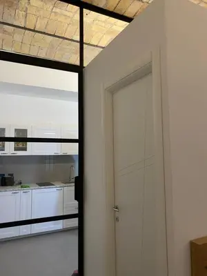 an open door to a kitchen with white cabinets at Il diamante del Colosseo in Rome