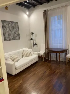 a living room with a white couch and a table at Tata Home Monti in Rome