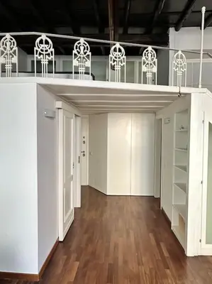 a large room with white cabinets and wooden floors at Tata Home Monti in Rome