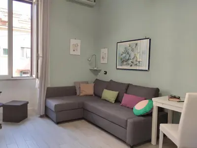 a living room with a gray couch with colorful pillows at La Casetta di Nonna Ro al Testaccio in Rome