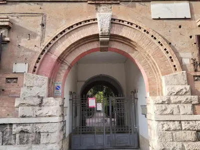 an archway in a brick building with a gate at La Casetta di Nonna Ro al Testaccio in Rome