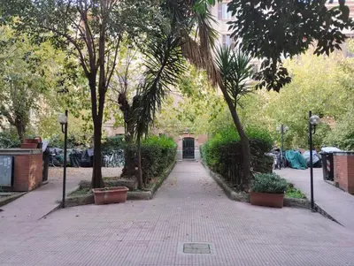 a walkway in a park with trees and a building at La Casetta di Nonna Ro al Testaccio in Rome