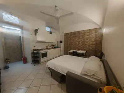 a bedroom with a large bed and a kitchen at MichaelHouse in Rome