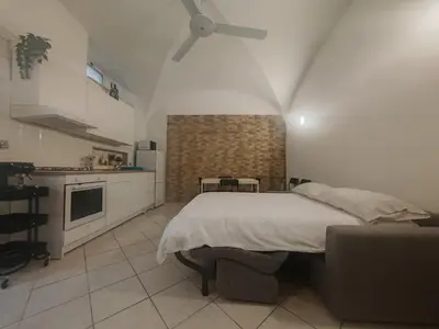 a bedroom with a large bed and a kitchen at MichaelHouse in Rome