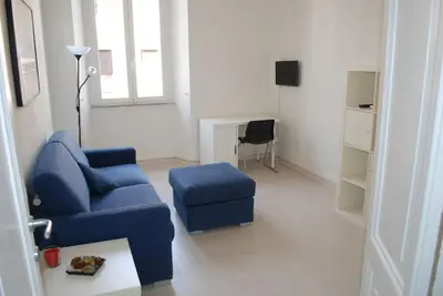 a living room with a blue couch and a chair at Affitti brevi Colosseo 2 in Rome