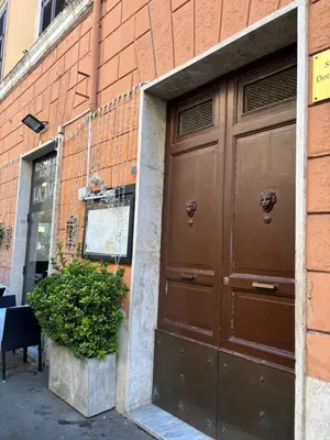 a large brown door on a building with a plant at Affitti brevi Colosseo in Rome
