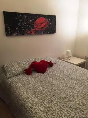a red heart pillow on a bed in a bedroom at Affitti brevi Colosseo in Rome