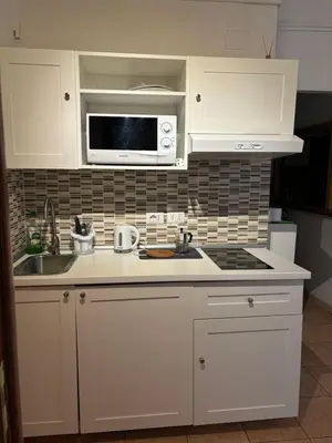 a white kitchen with a sink and a microwave at Affitti brevi Colosseo in Rome