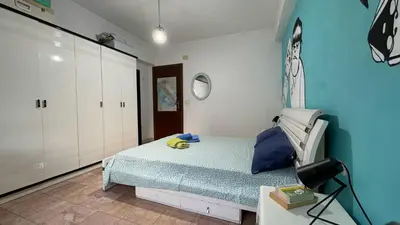 a bedroom with a bed and a blue wall at Camere artistiche in appartamento in Rome