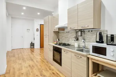 a kitchen with wooden cabinets and white appliances at Trieste Home! in Rome