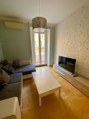 a living room with a couch and a tv at Lovely Apartment near metro A Re di Roma in Rome