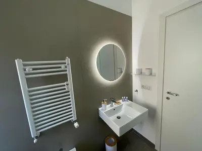 a kitchen with white cabinets and a sink at La Magnolia Monteverde Apartment in Rome