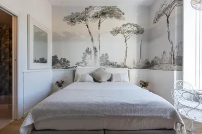a bedroom with a bed with trees on the wall at Primo Piano Suites Garden in Rome