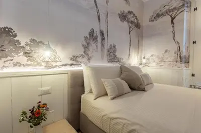 a bedroom with a bed with a painting on the wall at Primo Piano Suites Garden in Rome