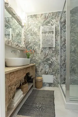 a bathroom with a sink and tropical wallpaper at Primo Piano Suites Garden in Rome