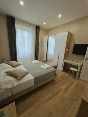a bedroom with a bed and a desk and a television at Linetta Charme House in Rome