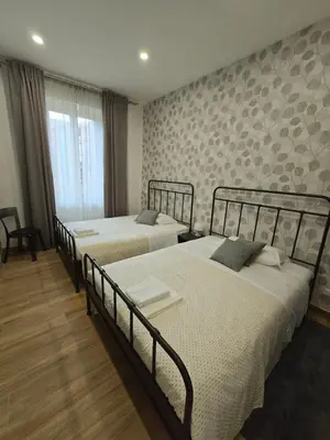 a bedroom with two beds and a window at Linetta Charme House in Rome