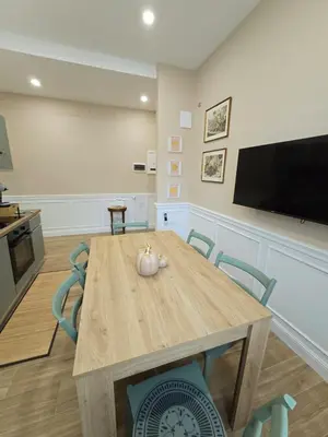 a dining room with a table with chairs and a flat screen tv at Linetta Charme House in Rome