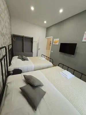 a hotel room with two beds and a flat screen tv at Linetta Charme House in Rome