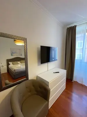 a room with a mirror and a chair and a tv at Ezio29 Holiday House in Rome