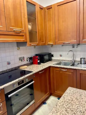 a kitchen with wooden cabinets and a stove and a sink at Ezio29 Holiday House in Rome