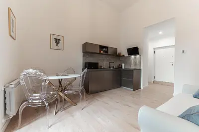 a kitchen with a table and chairs in a living room at Casa Martini - Vatican City and Metro Ottaviano in Rome