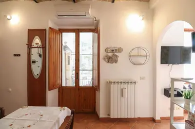 a room with a bed and a door and a television at Appartamento in via Plauto in Rome