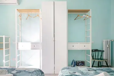 a bedroom with white cabinets and a bed and a chair at Roma centro Vicino al Vaticano - Free WiFi in Rome