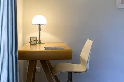 a desk with a lamp and a white chair at Casa Sardi in Rome