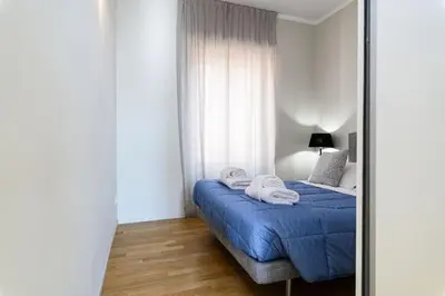 a bedroom with a bed with blue sheets and a mirror at Casa Sardi in Rome
