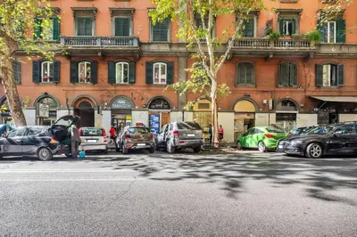 a parking lot with cars parked in front of a building at Apartment In Via Merulana Central Rome by Halldis in Rome