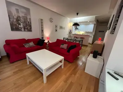 a living room with a red couch and a white table at My Home in Rome in Rome
