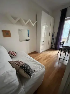 a white bedroom with a bed and a wooden floor at My Home in Rome in Rome