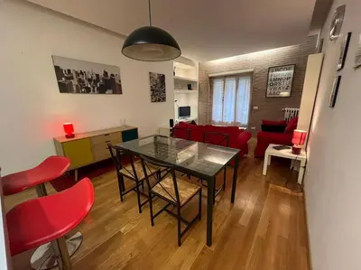 a living room with a table and red chairs at My Home in Rome in Rome