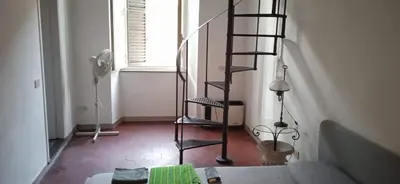 a spiral staircase in a living room with a couch at InsideRome Appartamento Vaticano e Centro Storico in Rome